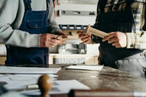 Carpenters Standing at the Table looking at woodworking plans